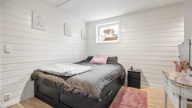 Soverom i utleiedelen med laminatgulv og malte panelvegger. Liten del av rommet er opprinnelig byggemeldt som bod.