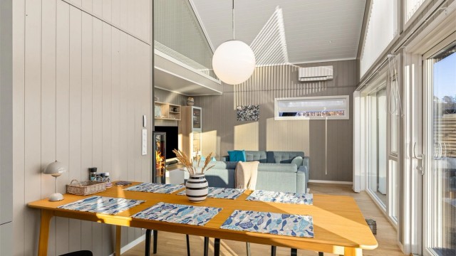 LYST: Store vinduer og skyvedører i glass gjør at lyset flommer inn i hytta.