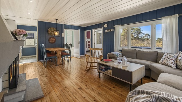 Vegger er malt i sommerlige fargevalg. De store vinduer skaper en lys og trivelig atmosfære i stuen.