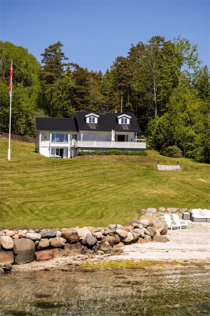 Hovedhuset ligger høyt og fritt på den skrånende tomten.