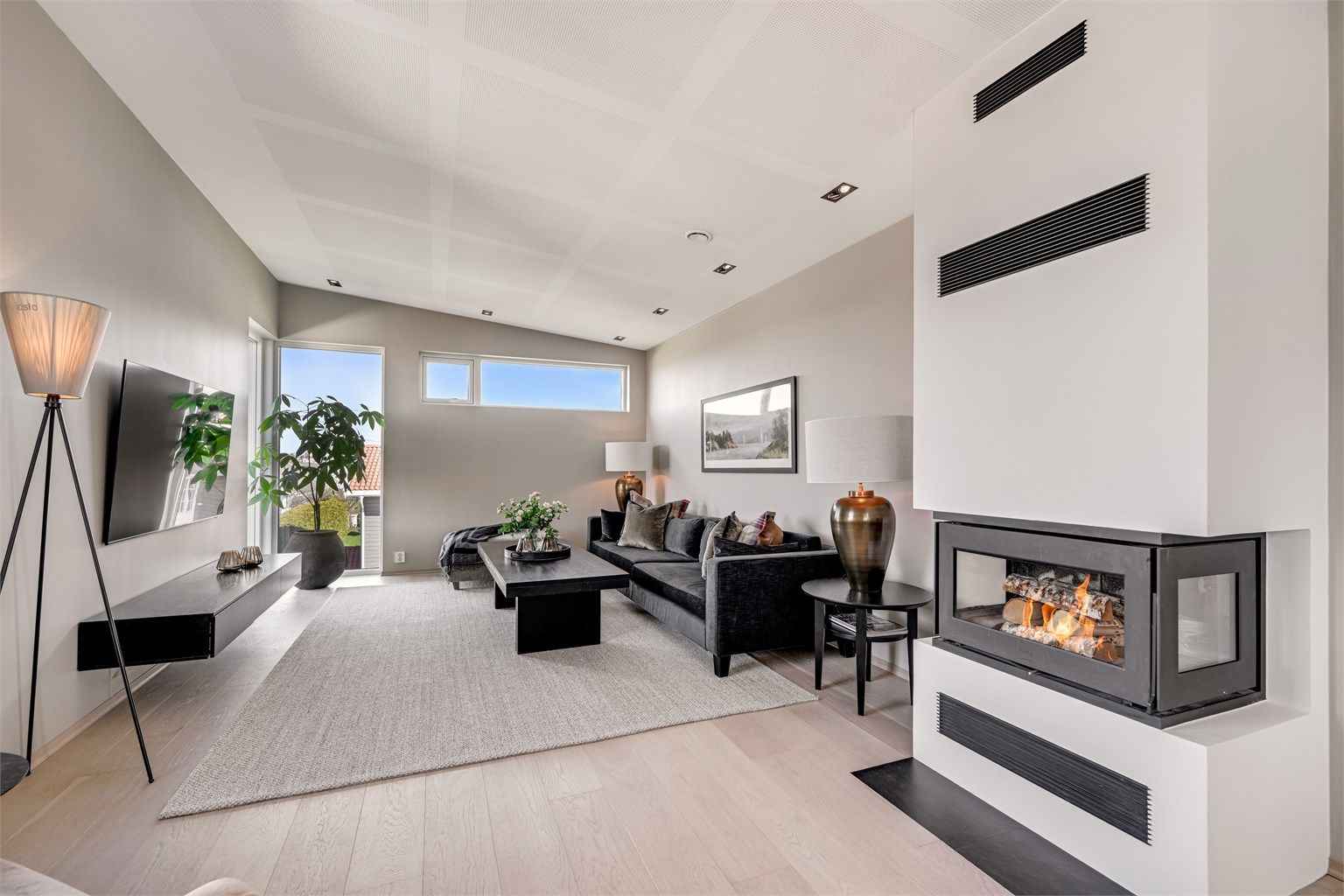 En moderne peis med isolert stålpipe skaper en lun atmosfære i stuen.