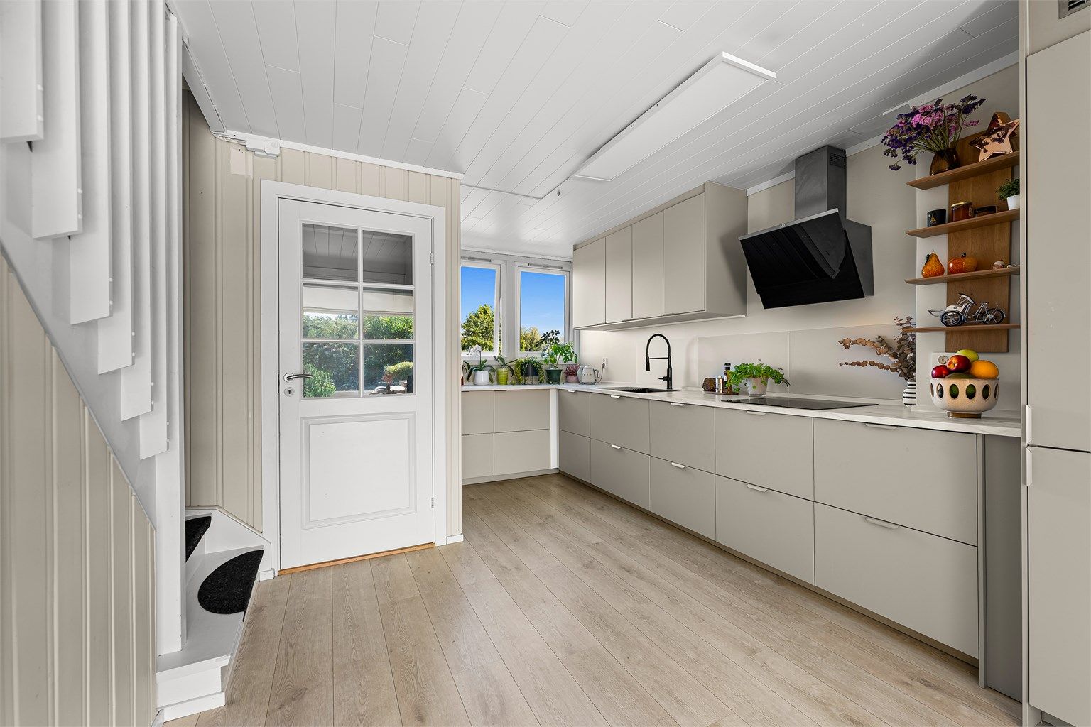  Innredningen består av lyse, slette fronter og en laminert benkeplate med nedfelt oppvaskkum.