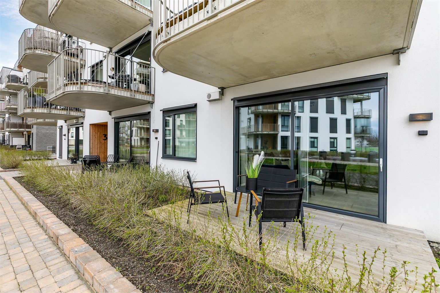 Ute på terrassen sitter du omgitt av sameiets parkmessige grøntarealer, vendt mot ettermiddags- og kveldssolen sommerstid.