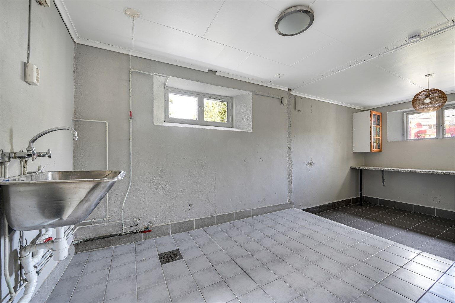 Stort vaskerom i underetasjen med utslagsvask, opplegg for vaskemaskin.