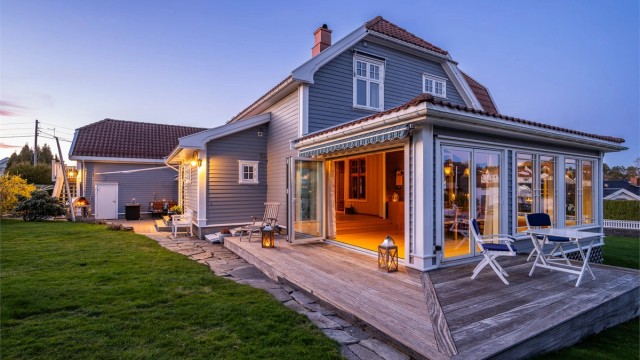 Spisestuen åpner boligen mot hagen med store foldedøre. Herfra er det utgang til en treterrasse på 25 m², som skaper en flytende overgang mellom inne- og uterom.