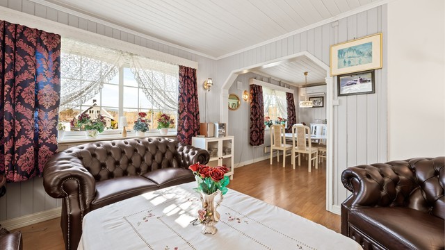 Stuen har en åpen løsning mot spisestuen, som skaper en sosial og sammenhengende sone i boligens første etasje.