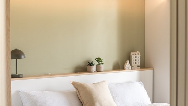 Integrert belysning i sengegavlen og de åpne hyllene skaper en lun og funksjonell nisje.