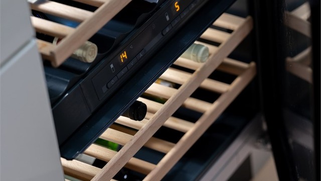 Kjøkkenøyen har integrert vinskap og benkeplate i sort granitt
