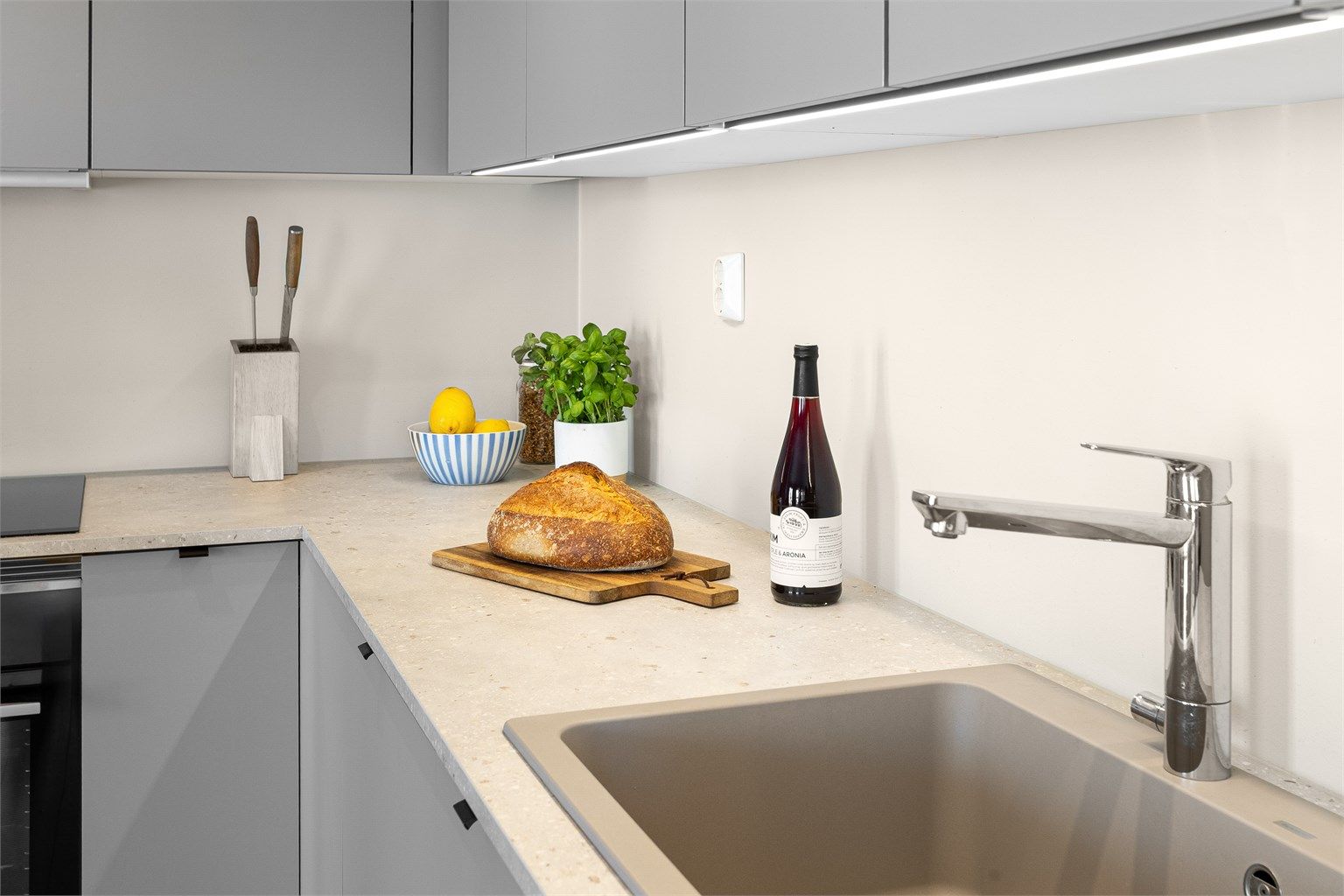  Innredning med glatte skapfronter, laminat benkeplate med nedfelt oppvaskkum og ett-greps armatur.