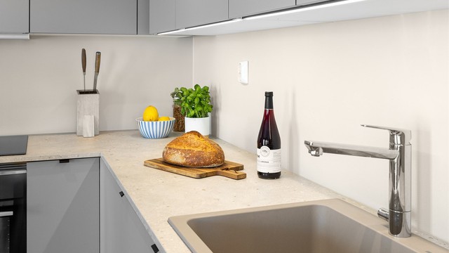 Innredning med glatte skapfronter, laminat benkeplate med nedfelt oppvaskkum og ett-greps armatur.