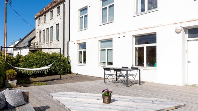 Terrassen er opparbeidet med platting i tre og har plassbygde sittebenker.
