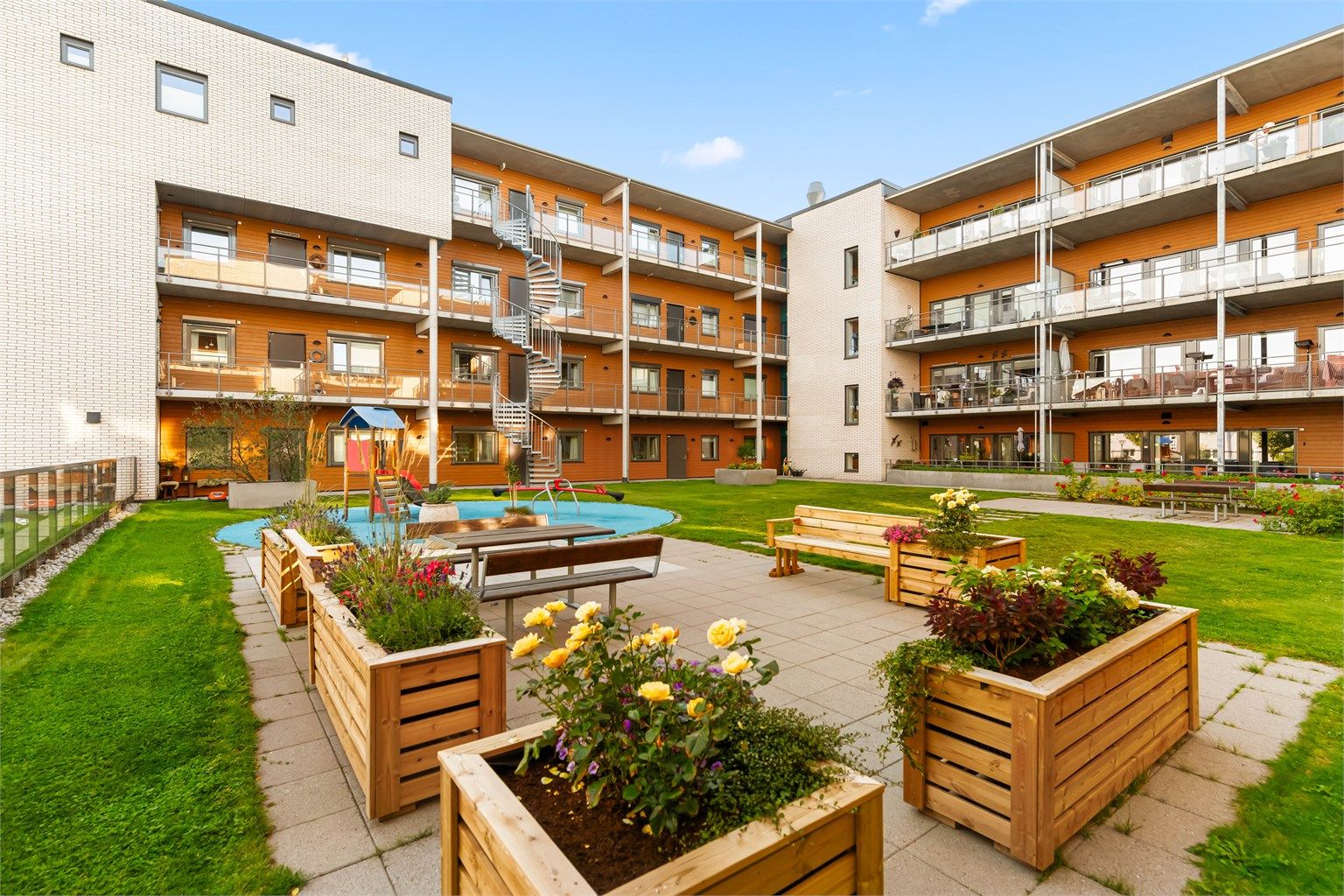 Nydelige fellesarealer med utegrupper for beboere og lekeplass for de minste (arkivbilde)