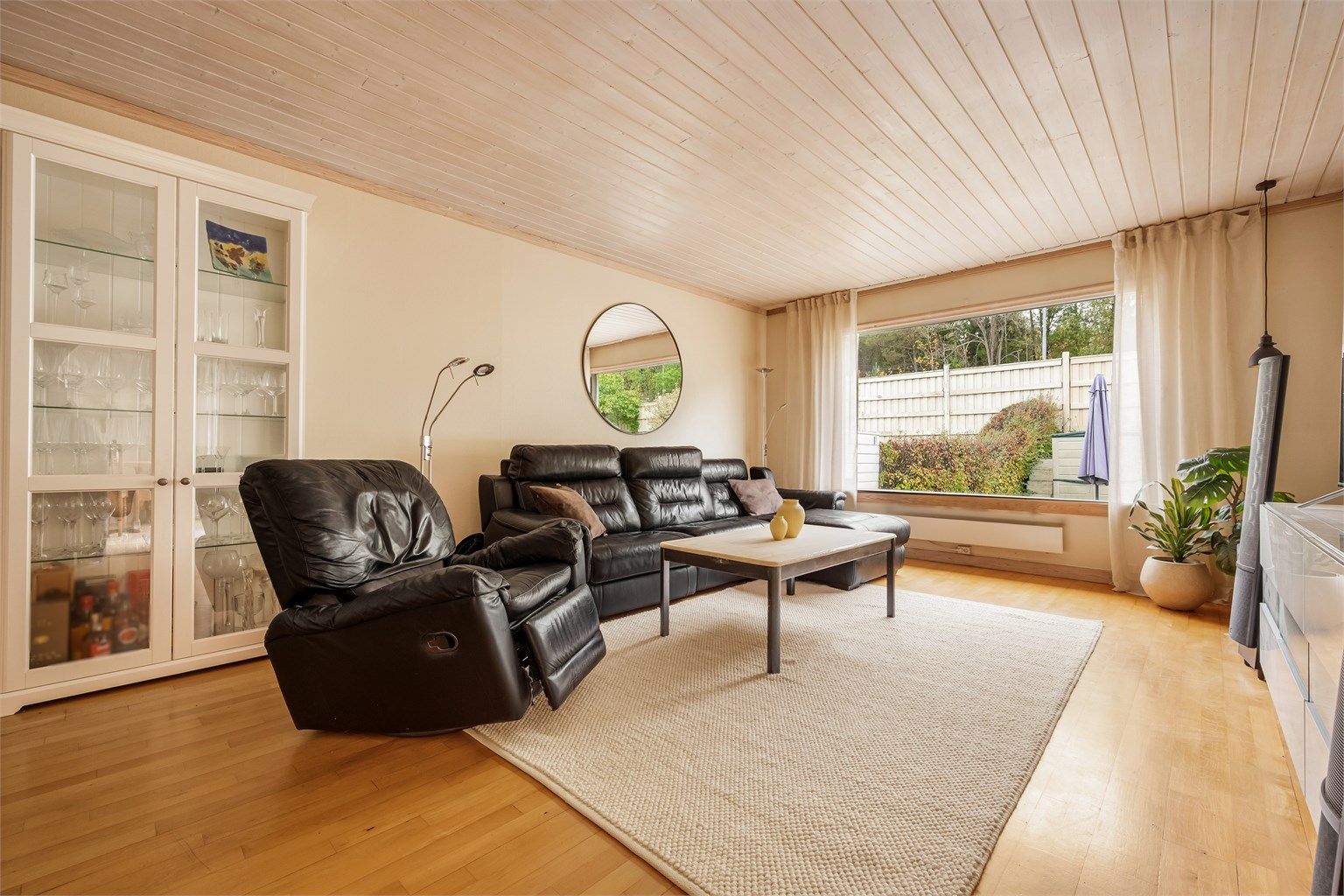 Romslig stue med god plass til sofagruppe og store vindusflater.
