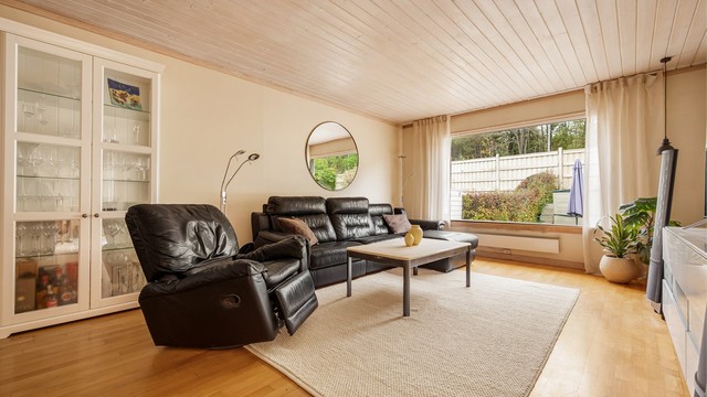 Romslig stue med god plass til sofagruppe og store vindusflater.