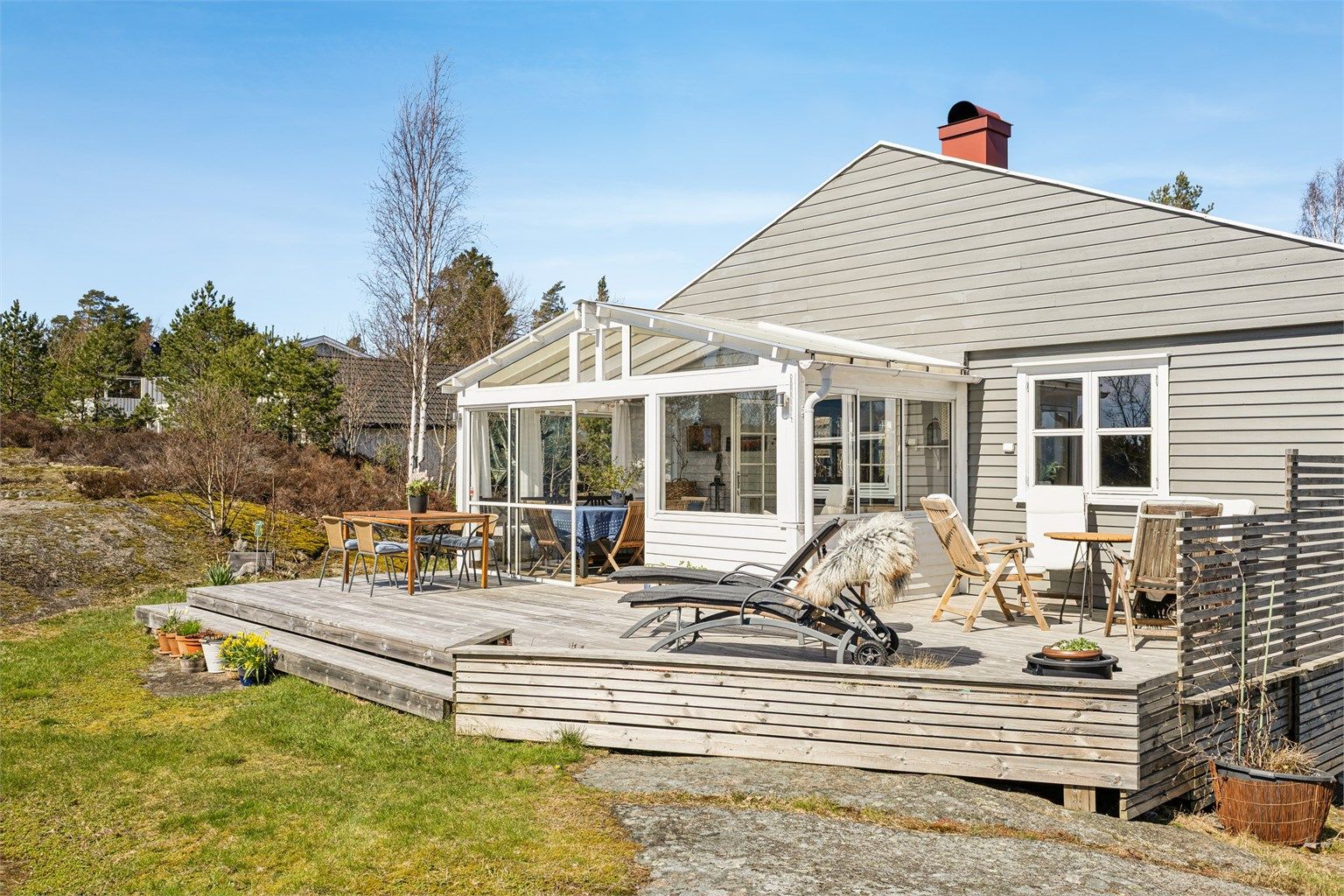 Romslig terrasse i trekonstruksjoner med tilknyttet innglasset utestue.
Foto: Efkt