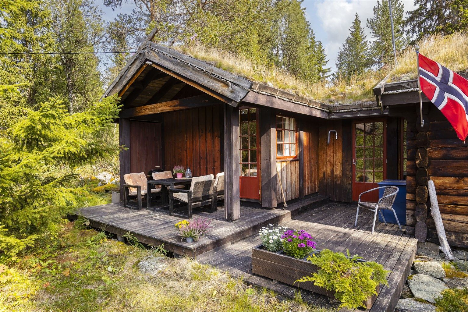 Lekker hytte i solid laftet tømmer og bindingsverk med stående kledning