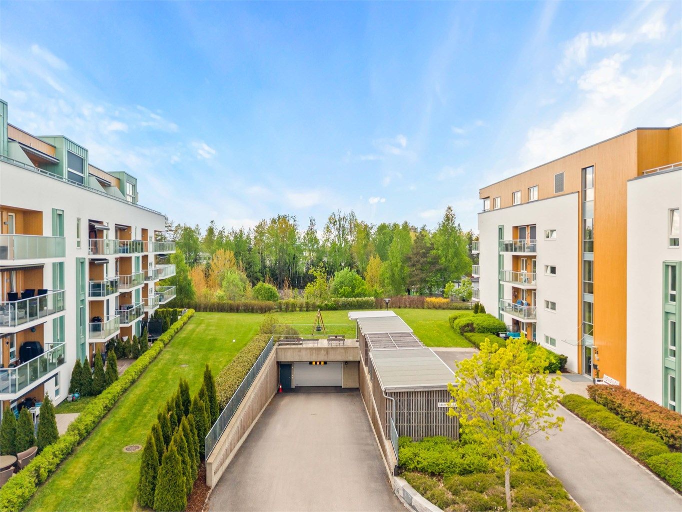 Fellesområdene er pent opparbeidet med plenarealer og beplantning, med nedkjøring til felles parkeringskjeller.