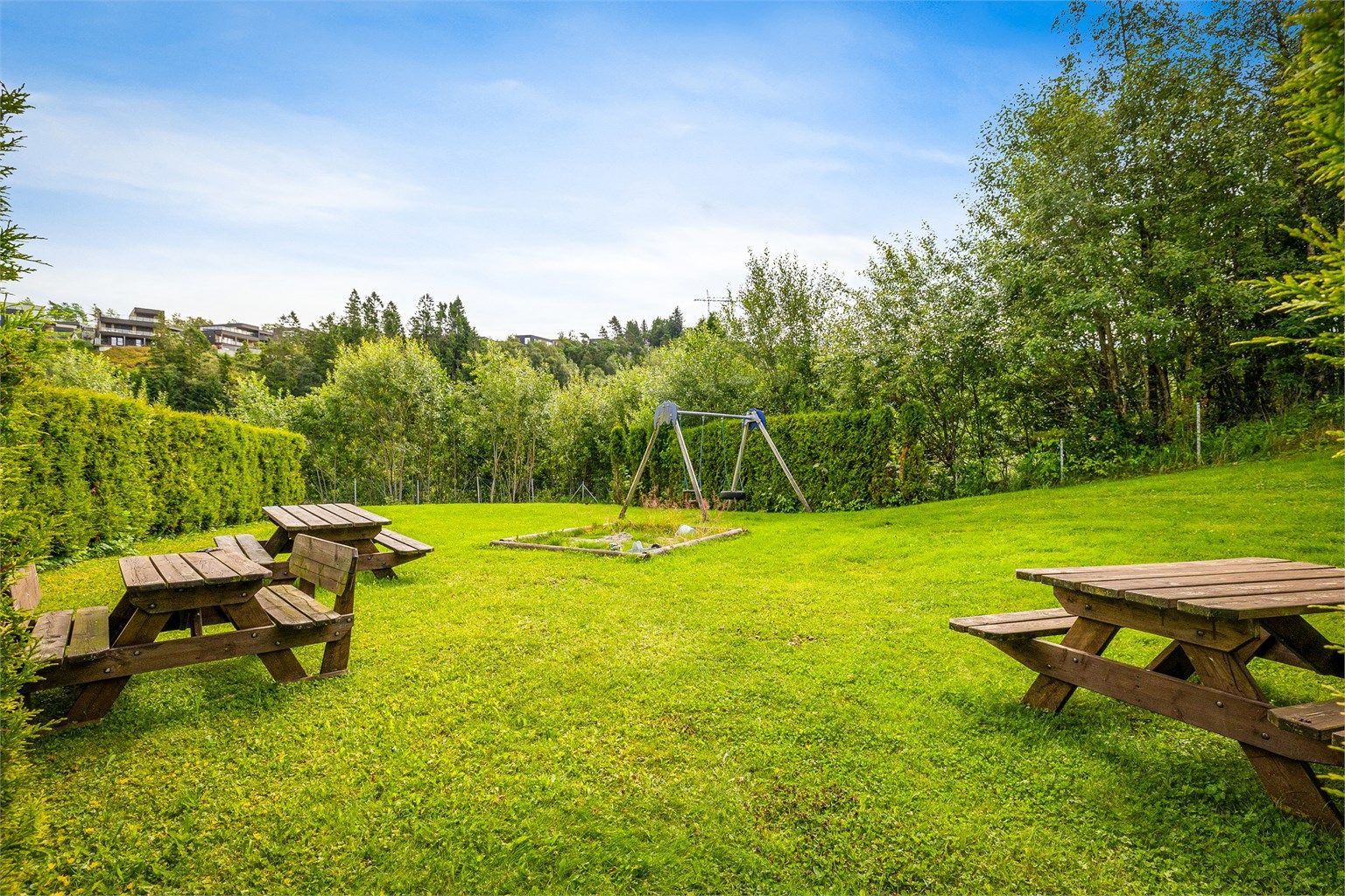 Fellesarealene er pent opparbeidet med skjermet lekeplass og grupper med benker.