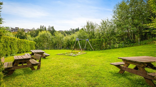 Fellesarealene er pent opparbeidet med skjermet lekeplass og grupper med benker.