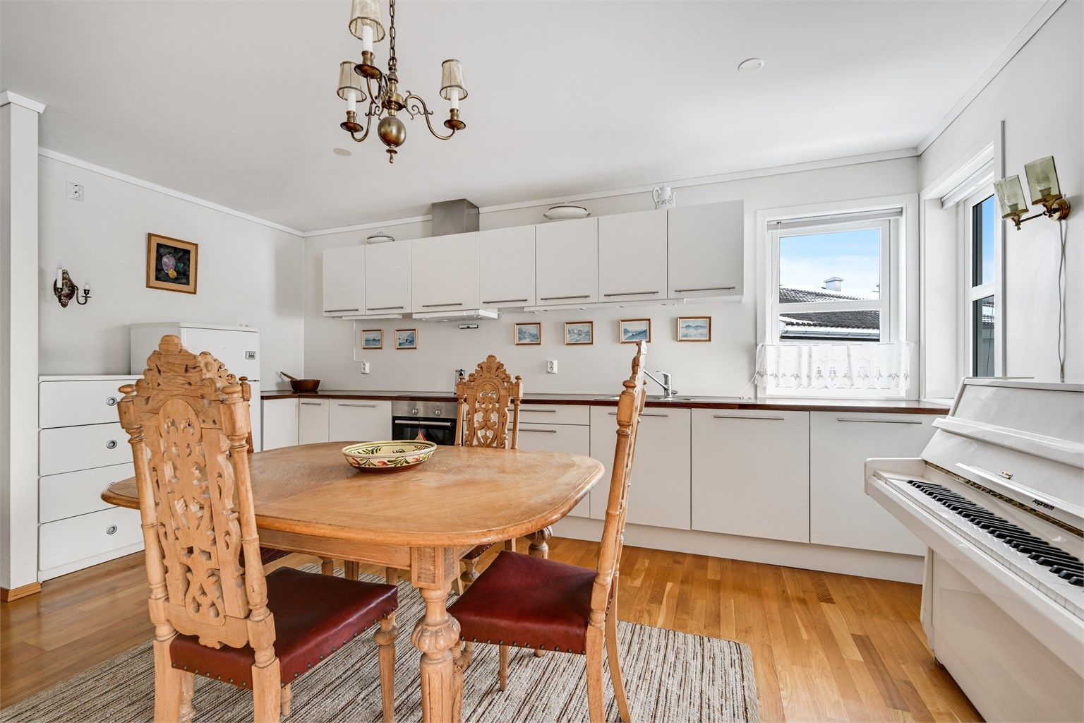 Kjøkkenet byr på rikelig med skapplass og gode arbeidsflater, og er utstyrt med integrert oppvaskmaskin, platetopp og stekeovn.