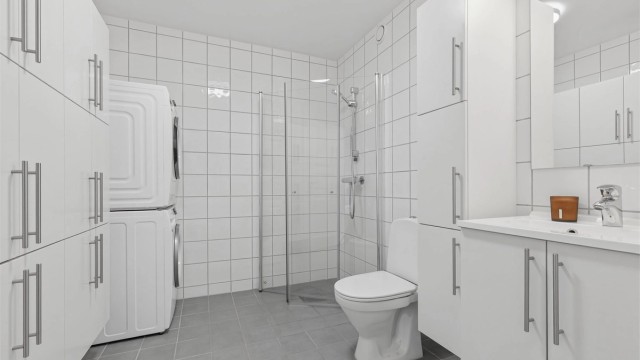 Leilighetens baderom er flislagt med gulvvarme, og har opplegg for vaskemaskin og tørketrommel.