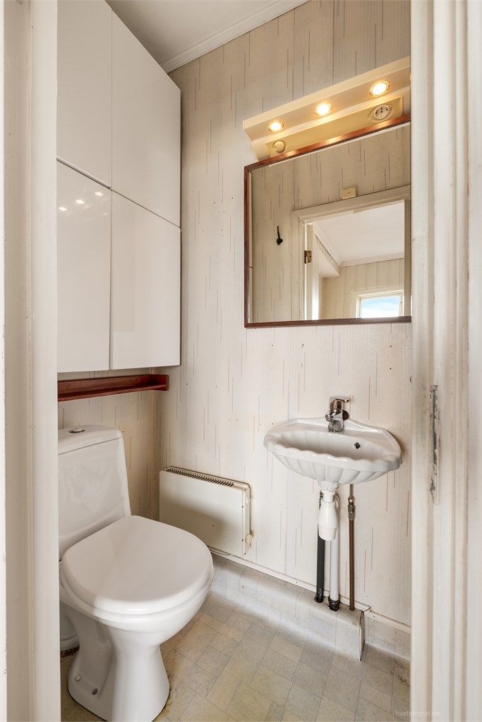 Badet har gulvstående toalett og dusjkabinett.
