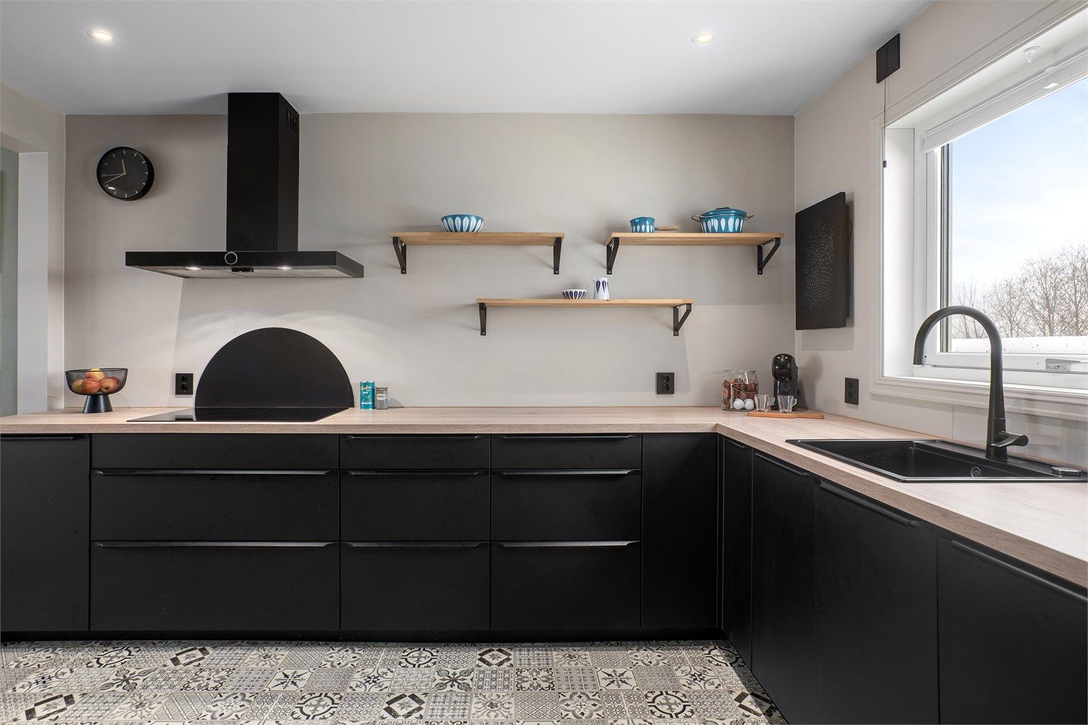 Kjøkkenet er innredet i mørke slette fronter og har rikelig med både skap- og benkeplass