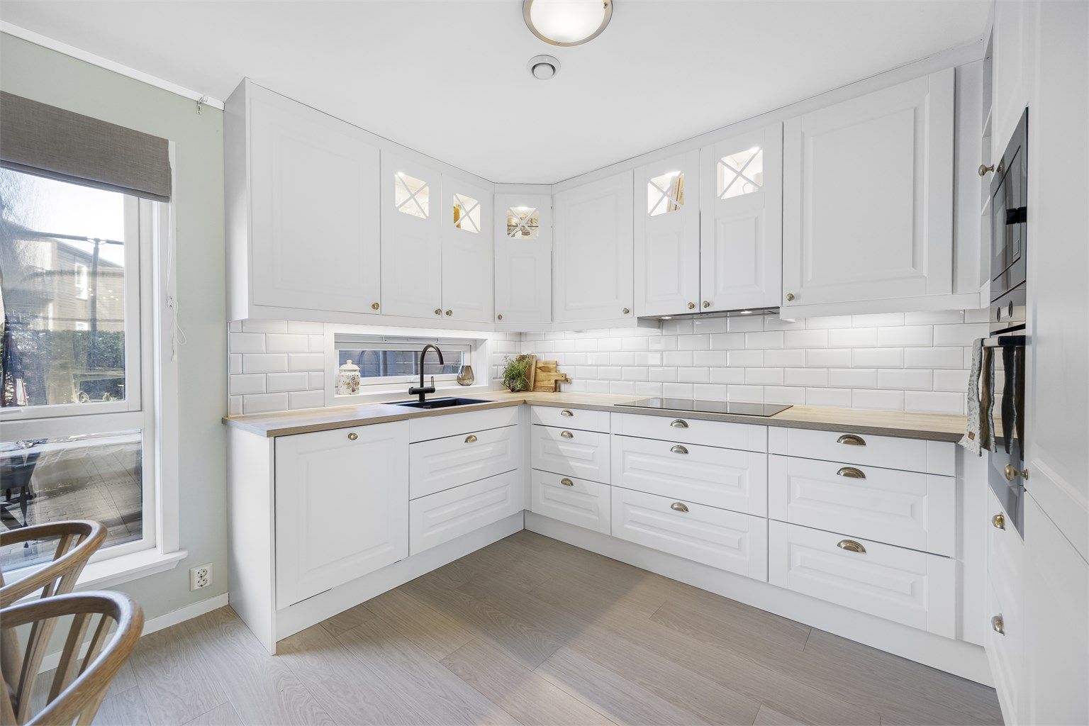 Innredningen har profilerte fronter, laminert benkeplate og fliser over benken.