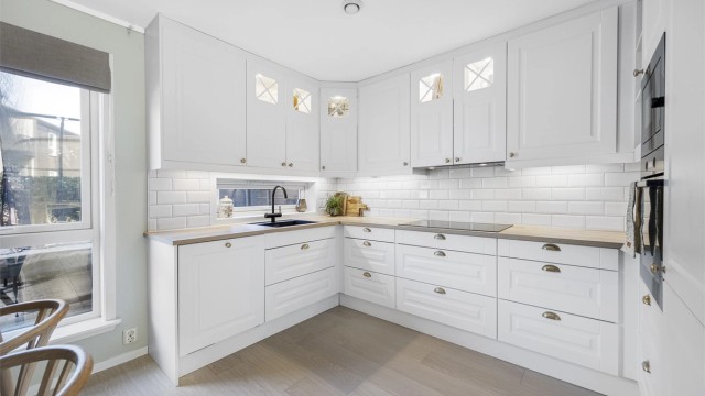 Innredningen har profilerte fronter, laminert benkeplate og fliser over benken.