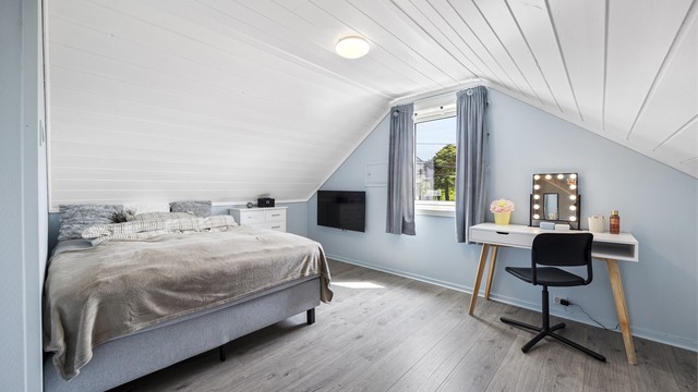 Det ene av to soverom på loftet. Rommet har plass til både seng og en liten arbeids- eller sminkeplass.