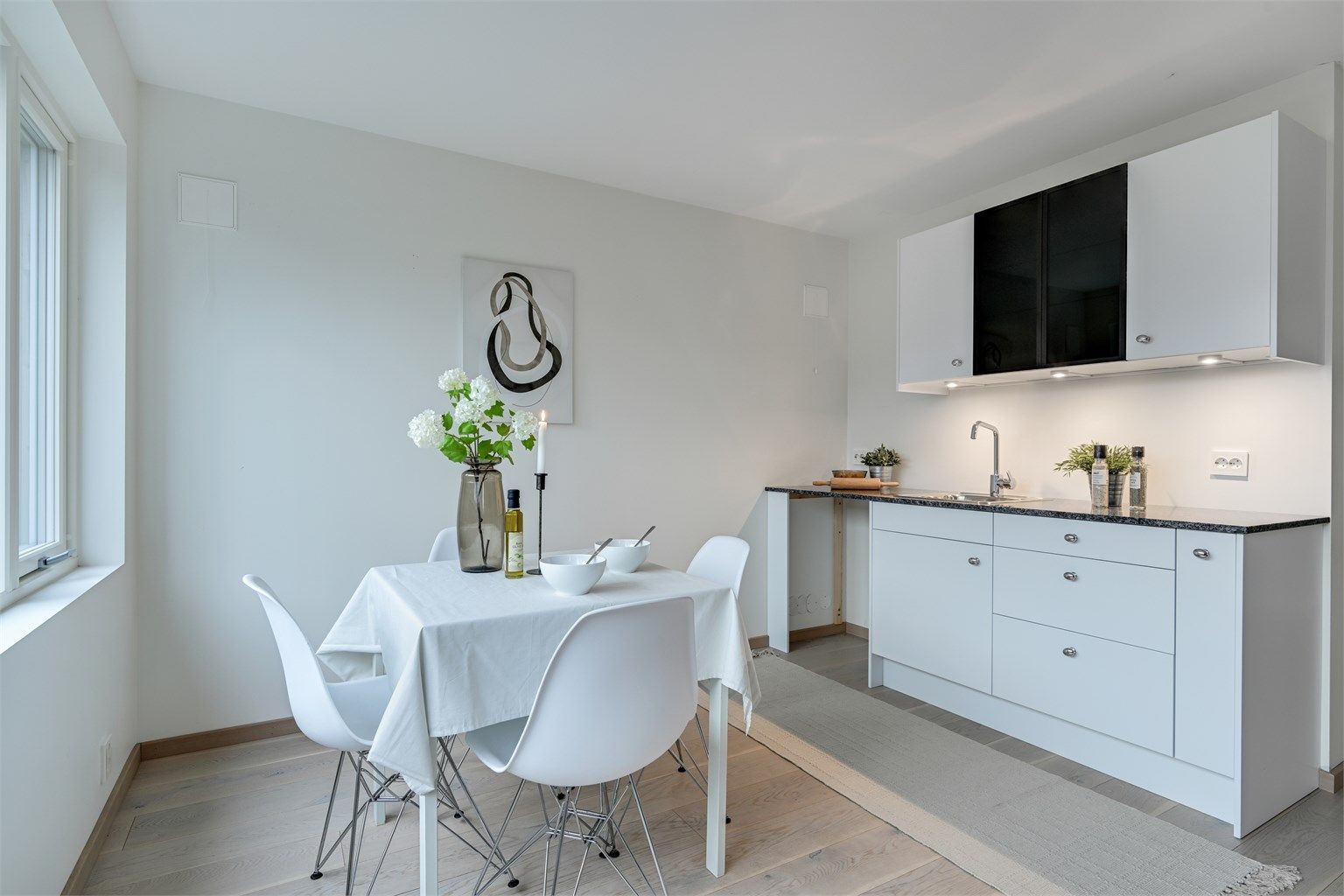 Kjøkkenløsningen er kompakt og funksjonell, med plass til en hyggelig spisekrok.