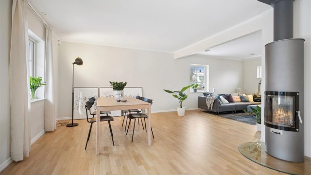 Stuen er av god størrelse og er malt i en lys, delikat farge, har parkett på gulvet og en moderne peisovn for hygge og varme.