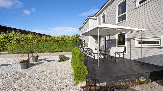 Blåklokkesvingen 27 - Enebolig i kjede over to plan med carport og opparbeidede uteplasser på begge sider av boligen.