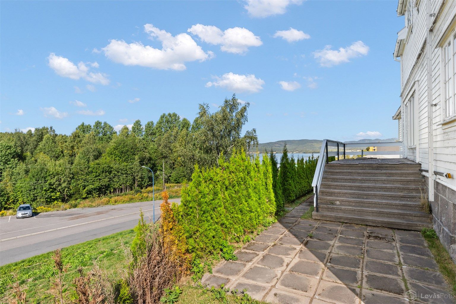 Hellelagt uteplass ved inngangspartiet med trapp opp til terrassen.