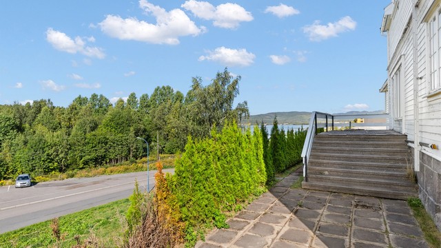 Hellelagt uteplass ved inngangspartiet med trapp opp til terrassen.