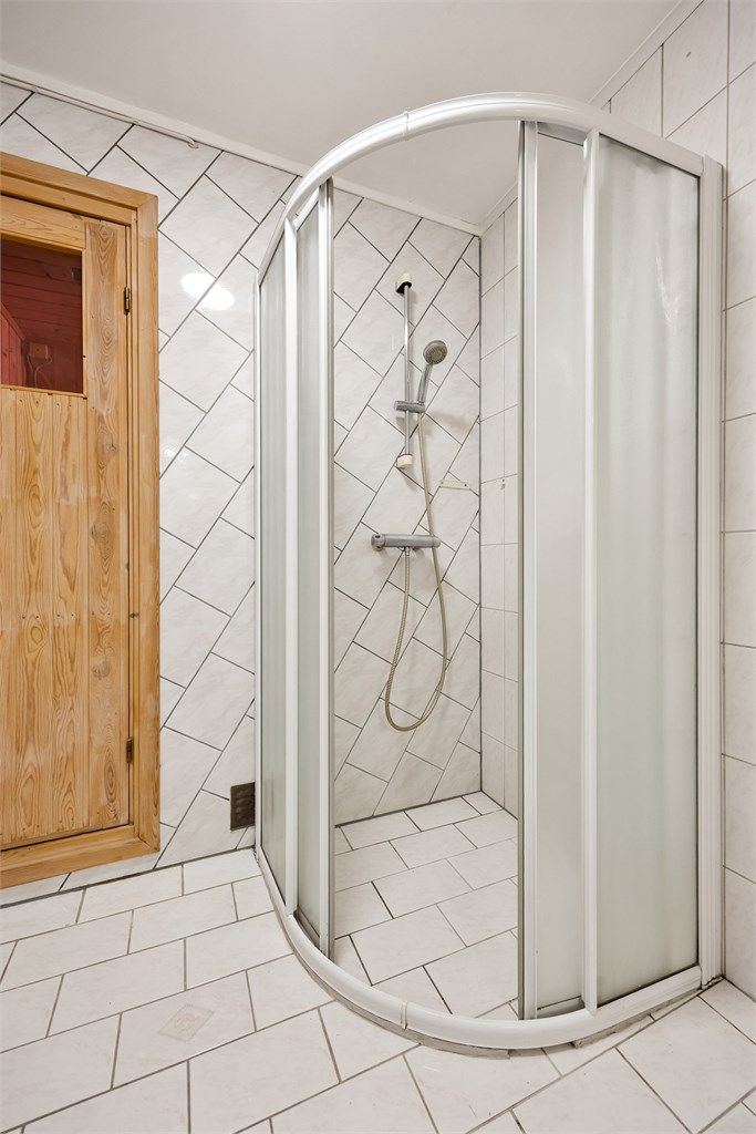 Badet er utstyrt med dusjhjørne med dører. Herfra er det adkomst til badstuen.