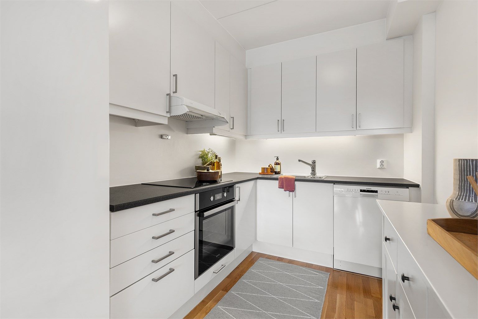 Lyst og fint kjøkken med slette hvite fronter.