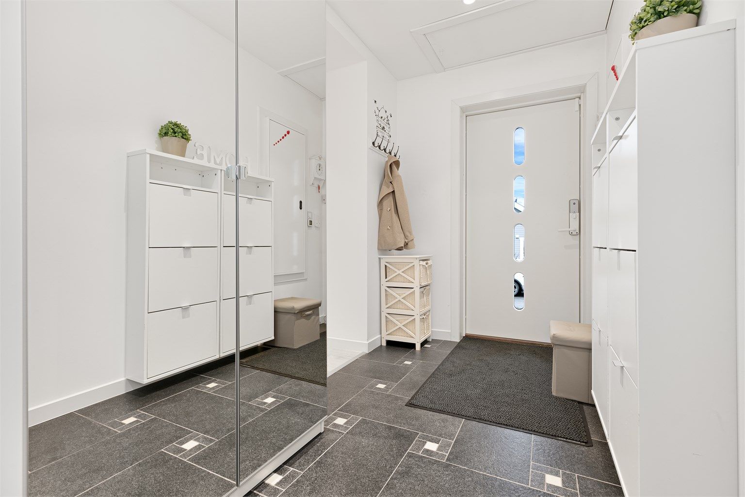 Inngangspartiet har flislagt gulv med gulvvarme og gode oppbevaringsmuligheter.