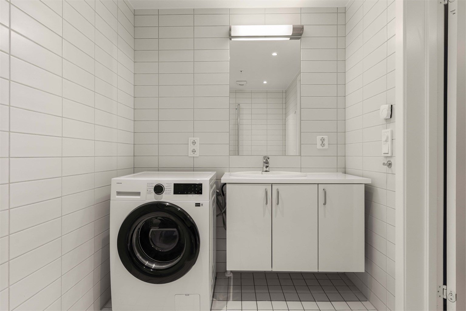 Flislagt bad med elektrisk gulvvarme og opplegg for vaskemaskin.