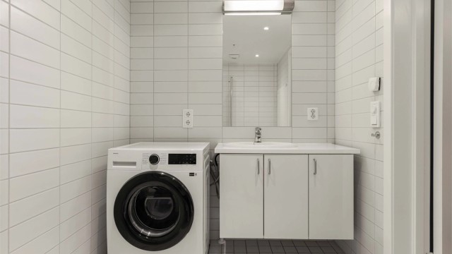 Flislagt bad med elektrisk gulvvarme og opplegg for vaskemaskin.