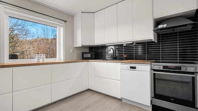 Kjøkkenet er videre innredet med integrert kjøleskap, frittstående komfyr og oppvaskmaskin og har rikelig med skap og benkeplass.