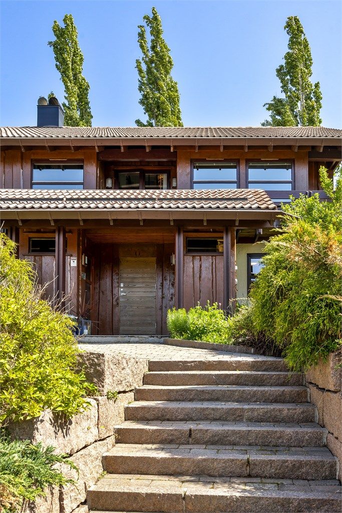 Støttemurer av naturstein rammer inn gårdsplassen og hagen.