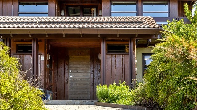 Støttemurer av naturstein rammer inn gårdsplassen og hagen.
