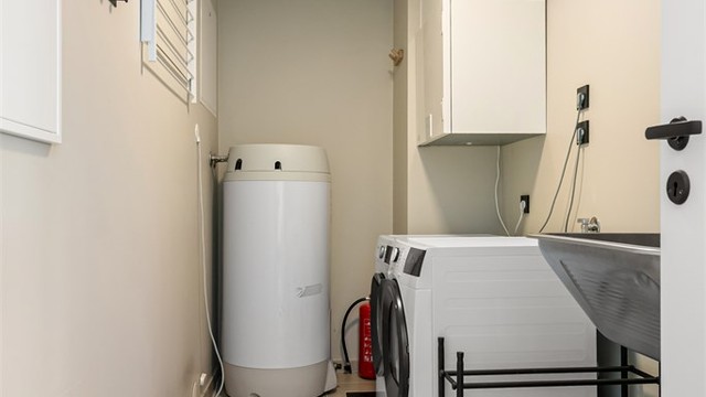 Vaskerom med flislagt gulv, gulvvarme, opplegg for vaskemaskin og plassering av tekniske installasjoner.