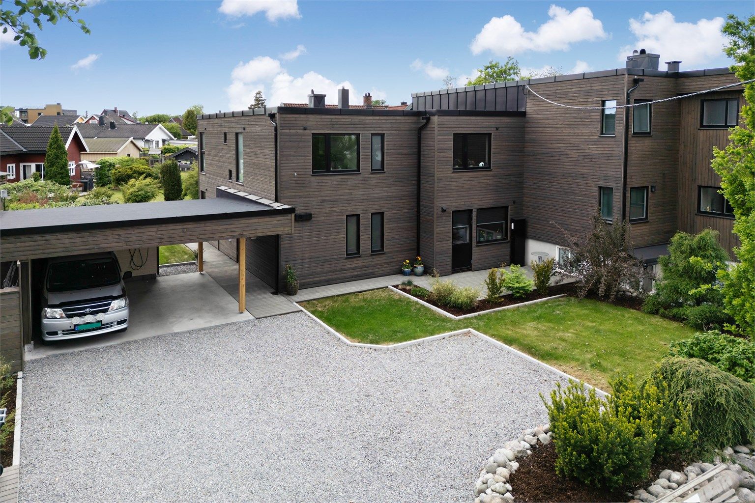 Pent opparbeidet gårdsplass med flere biloppstillingsplasser - Dobbel carport med bod i bakkant