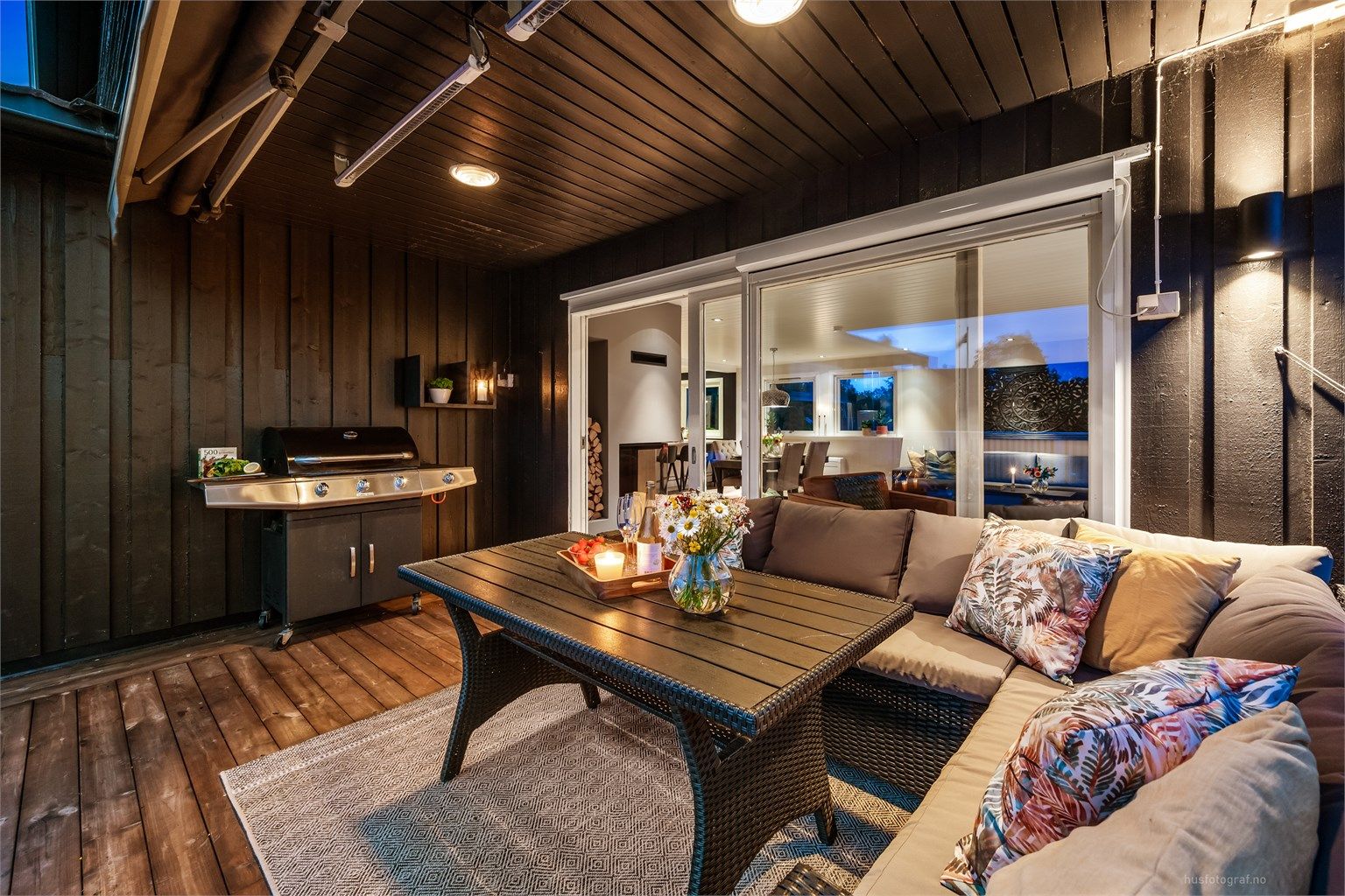 Overbygget del av terrassen med plass til grill og sofagruppe.