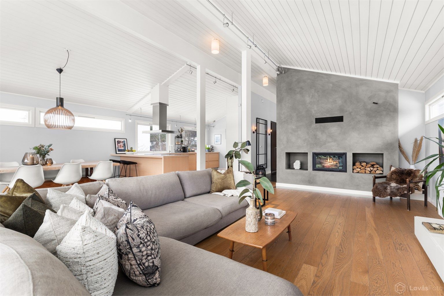 Den imponerende takhøyden på inntil 3,60 meter og peisovnen skaper en luftig og stemningsfull atmosfære.