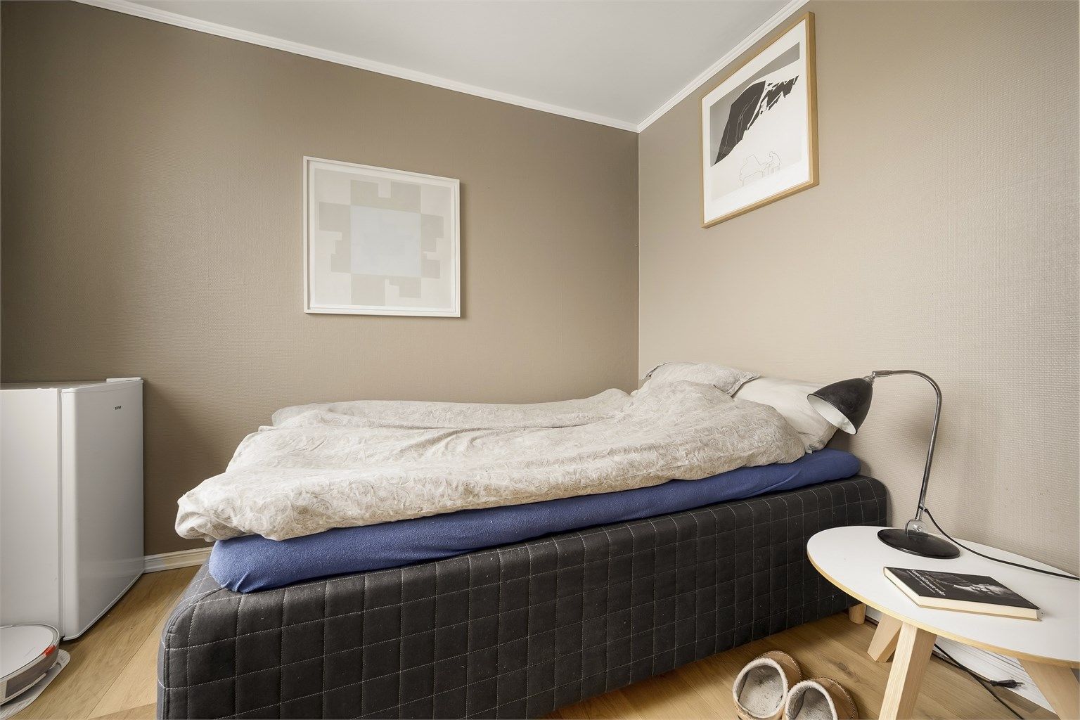 Rommet har plass til en større seng og tilhørende møblement.