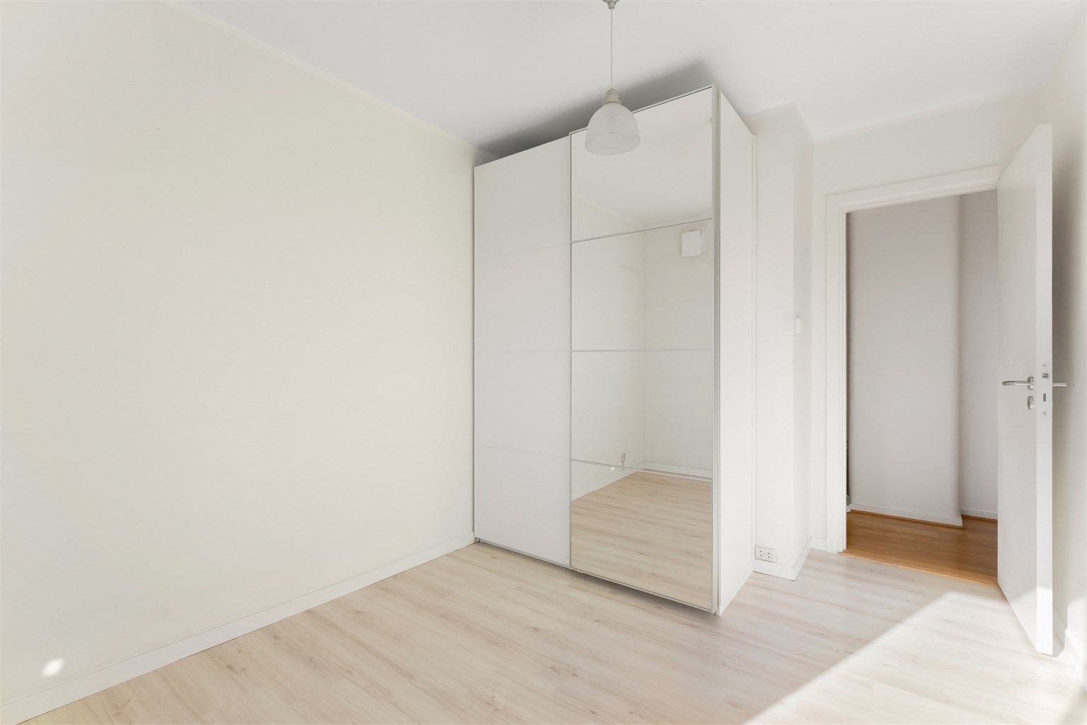 En stor garderobeløsning med speilfronter gir rikelig med oppbevaringsplass.