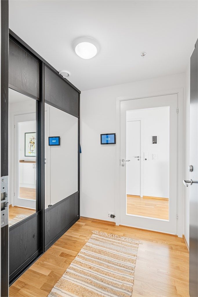 I entréen er det stor skyvedørsgarderobe - Her ser du portelefonen med kamera på veggen også
